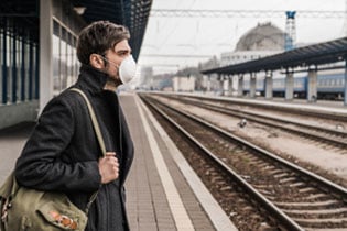 male in train station wearing mask