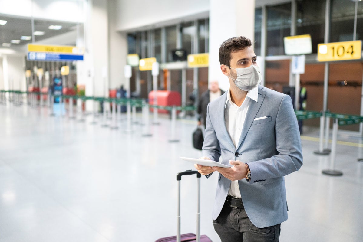 Male walking through airport with face covering