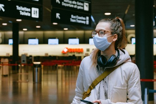 Mujer joven con máscara en el aeropuerto