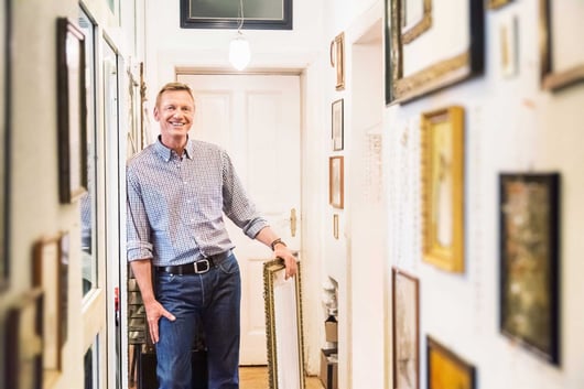 Man standing next to his art collection