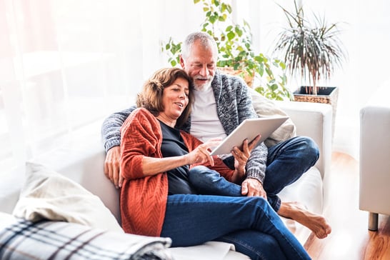 Senior-couple-with-ipad-relaxing-at-home