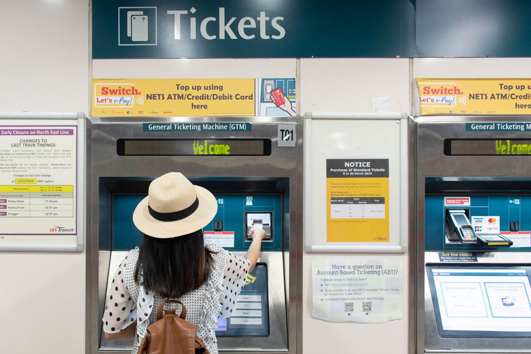 Woman buying ticket at Singapore train station