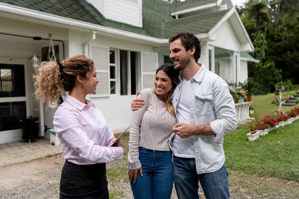Young couple and real estate agent outside home