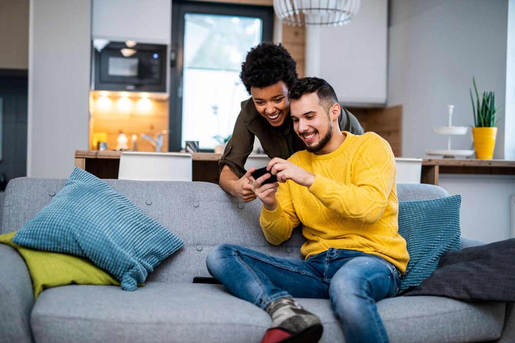 Young couple using smart phones in the living room