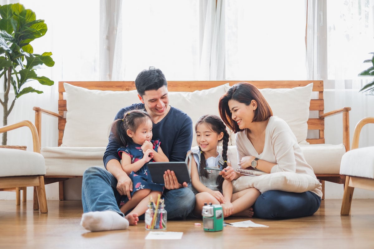 Asian family sitting on floor in new home