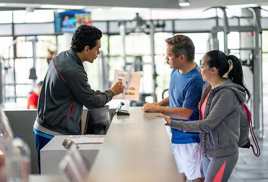 happy-couple-registering-at-the-gym
