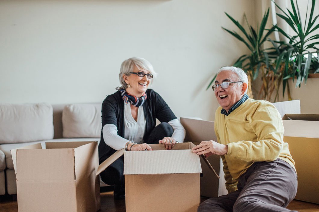 Senior couple unpacking boxes in new home