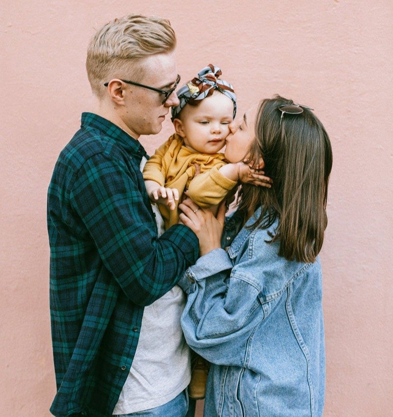 Young family with baby hugging