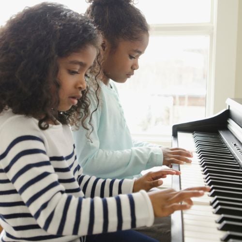 two girls playing piano